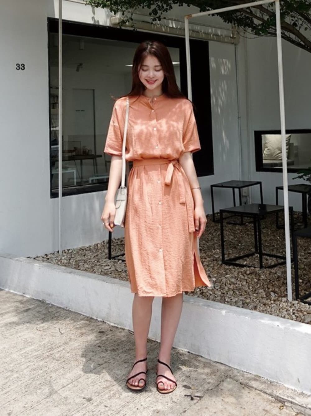 オレンジ系のシャツワンピースを着用したレディースの夏コーディネートの1枚目の写真