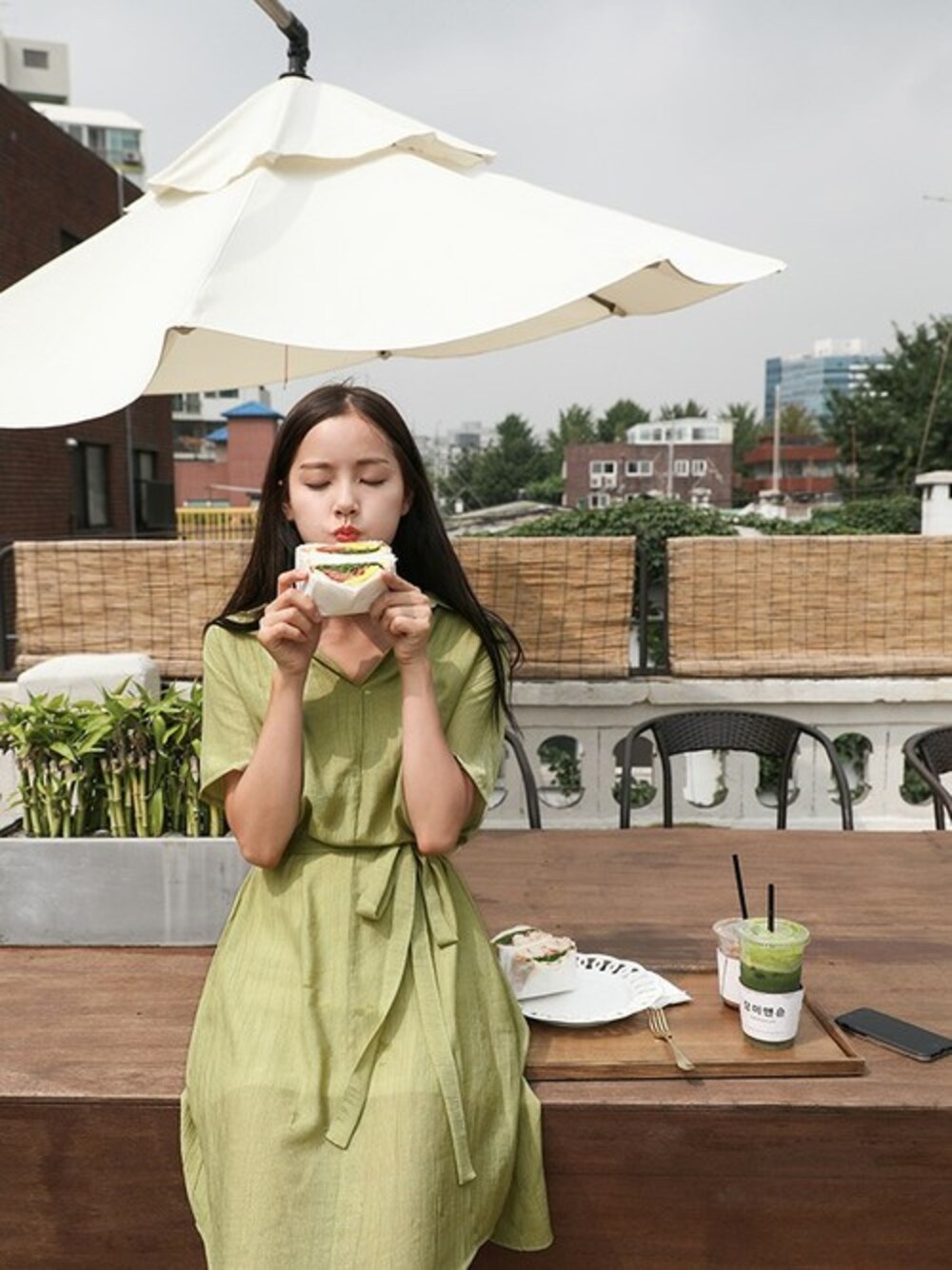 グリーン系のワンピースを着用したレディースの夏コーディネートの1枚目の写真