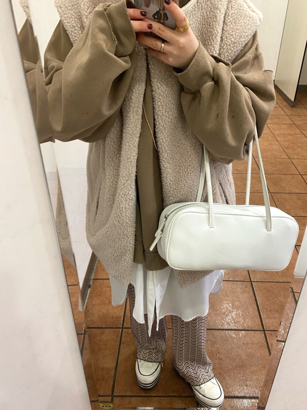 ブラウン系のTシャツ/カットソー、ベージュ系のベスト、ホワイト系のシャツ/ブラウスを着用したレディースの春コーディネートの1枚目の写真