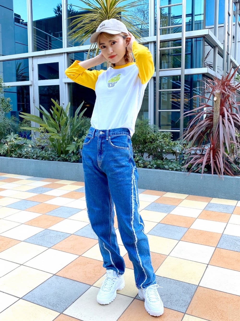 ブルー系のデニムパンツ、イエロー系のTシャツ/カットソー、ベージュ系のキャップを着用したレディースの夏コーディネートの1枚目の写真