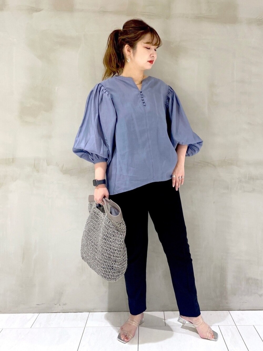 ブルー系のシャツ/ブラウス、ブラック系のその他パンツ、グレー系のクラッチバッグを着用したレディースの春コーディネートの1枚目の写真