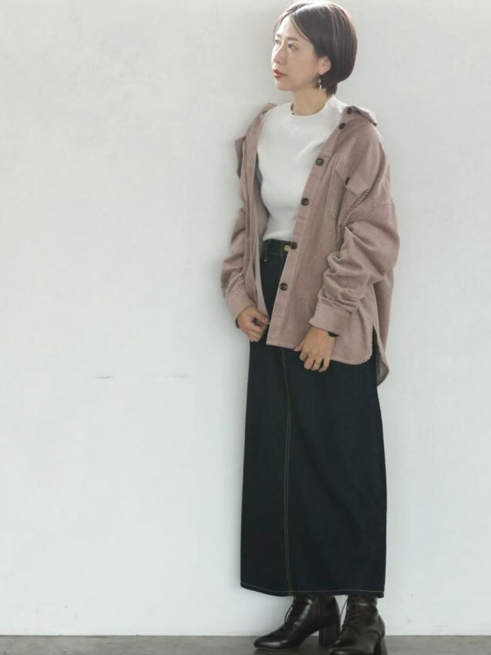 ピンク系のその他アウター、ブルー系のデニムスカート、ベージュ系のニット/セーターを着用したレディースの秋コーディネートの1枚目の写真