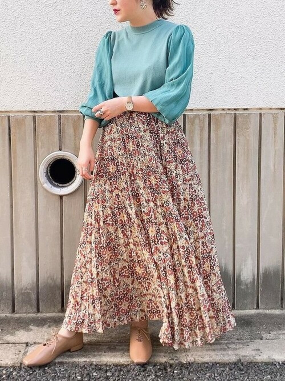 グリーン系のニット/セーター、ホワイト系のスカート、ベージュ系のドレスシューズを着用したレディースの秋コーディネートの1枚目の写真