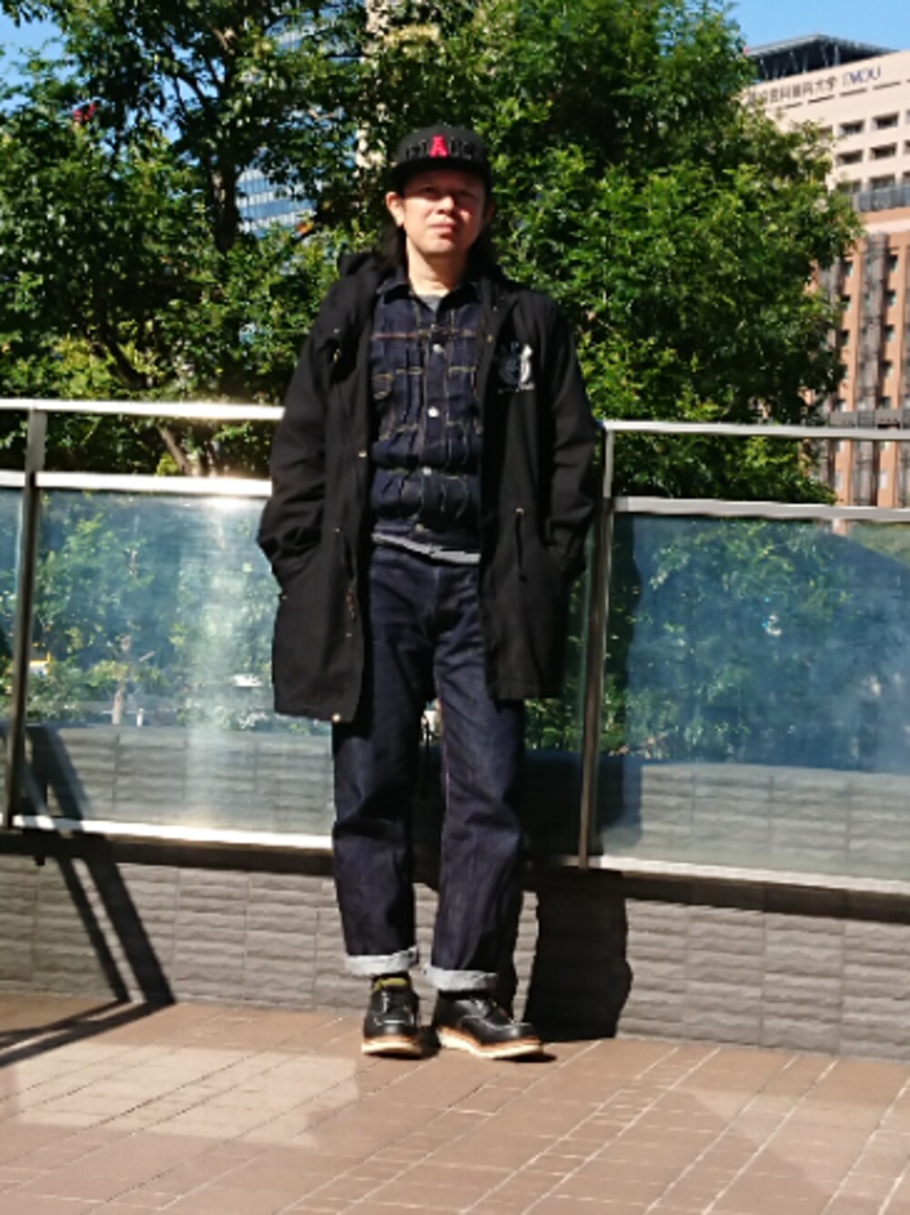 ブルー系のデニムパンツ、ブルー系のデニムジャケット、ブラック系のモッズコートを着用したメンズの冬コーディネートの1枚目の写真