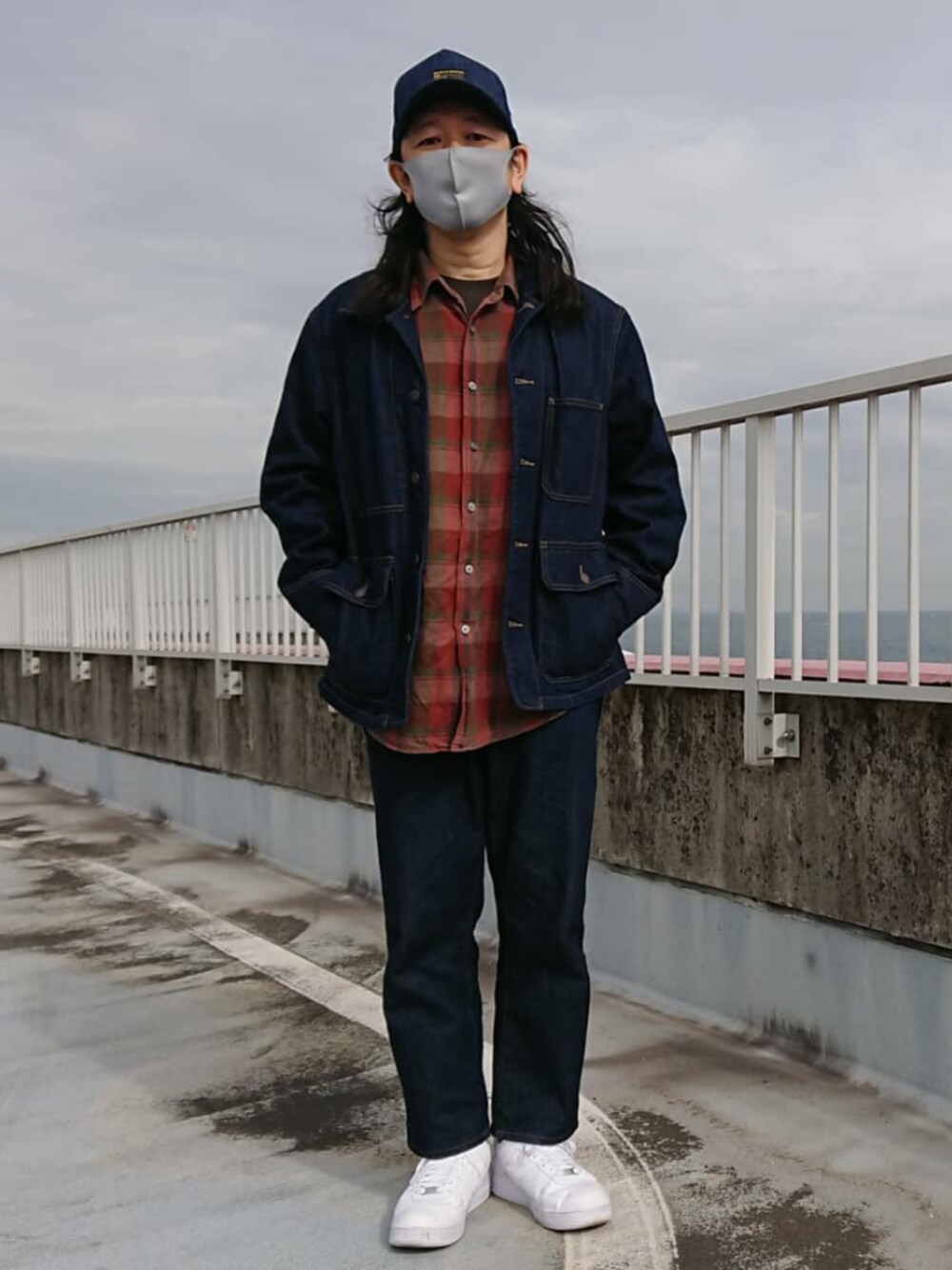 ブルー系のデニムパンツ、ホワイト系のスニーカー、ブルー系のデニムジャケットを着用したメンズの冬コーディネートの1枚目の写真