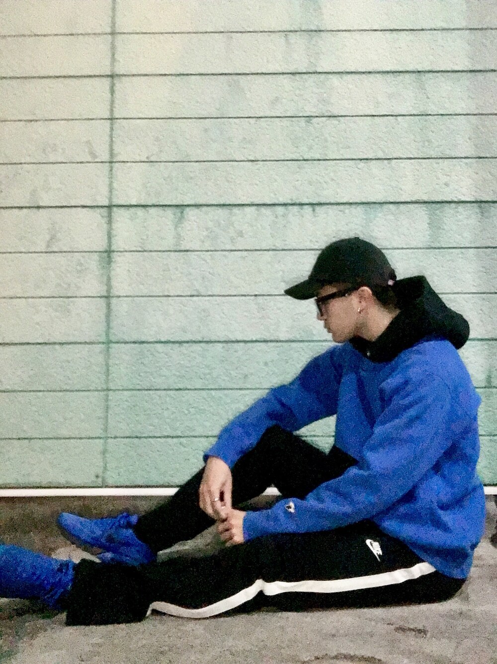 ブルー系のパーカー、ブラック系のその他パンツ、ブルー系のスニーカーを着用したメンズの冬コーディネートの1枚目の写真