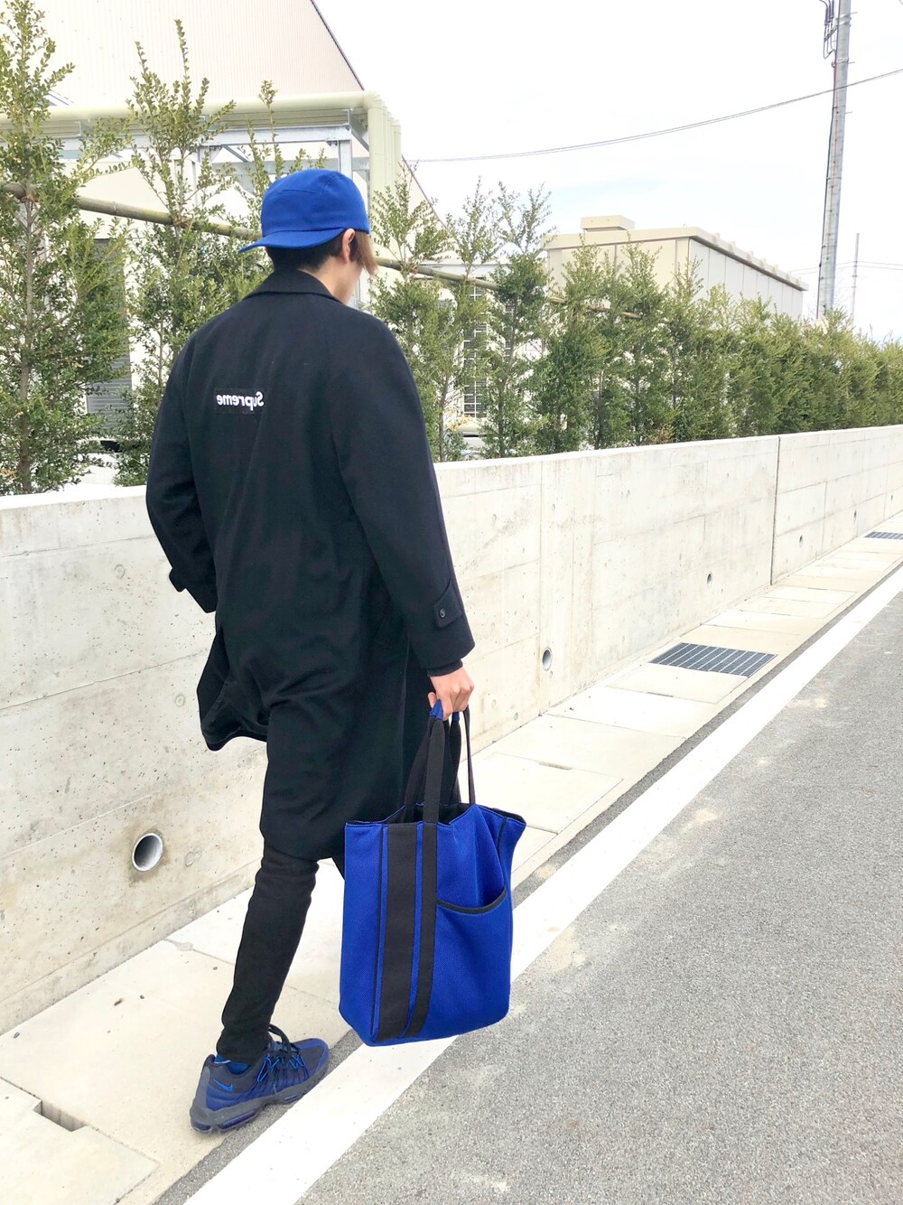 ブルー系のスニーカー、ブルー系のトートバッグ、ブラック系のその他パンツを着用したメンズの春コーディネートの1枚目の写真