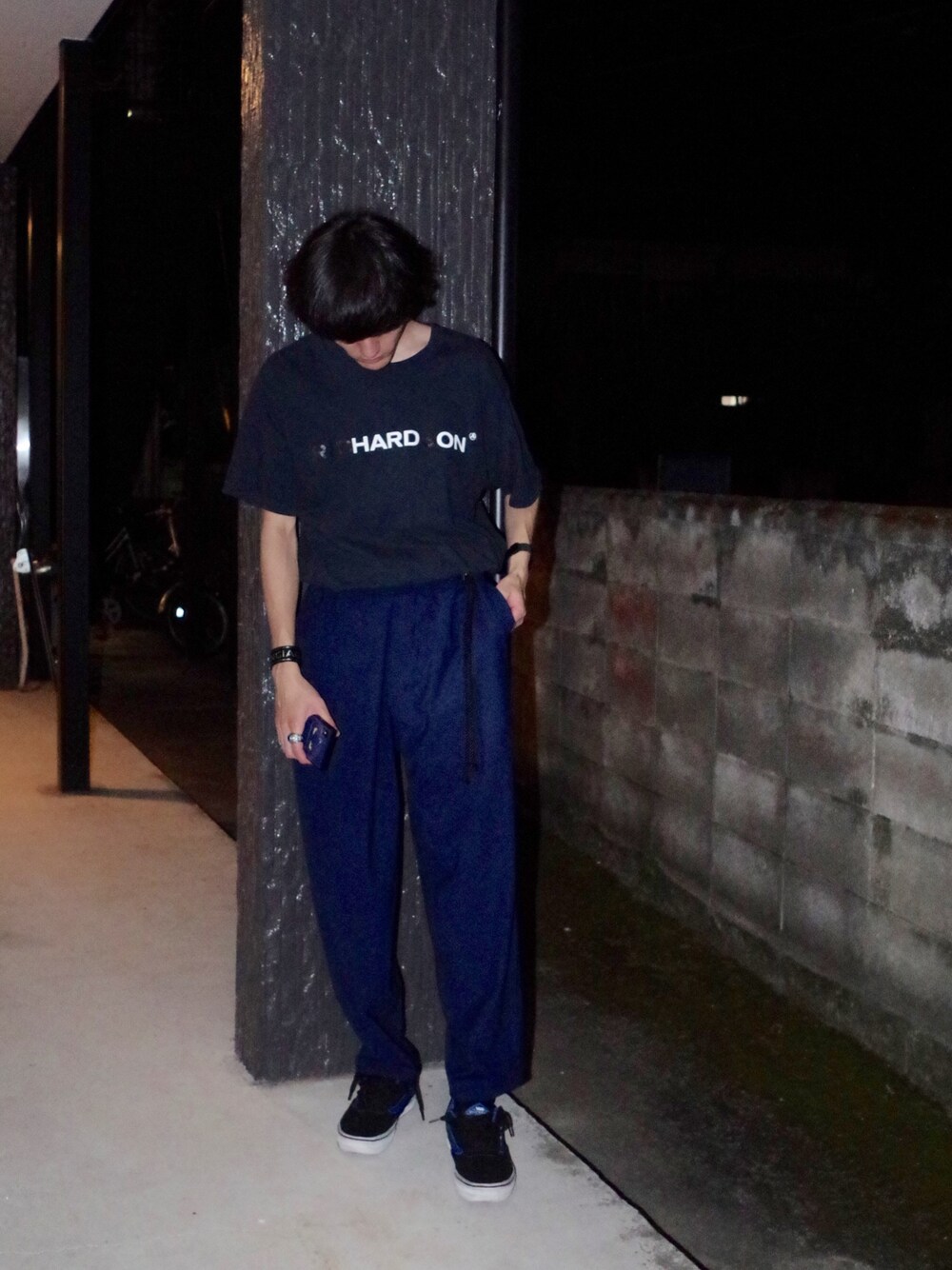 ブラック系のTシャツ/カットソー、ブルー系のスラックス、ブラック系のスニーカーを着用したメンズの夏コーディネートの1枚目の写真