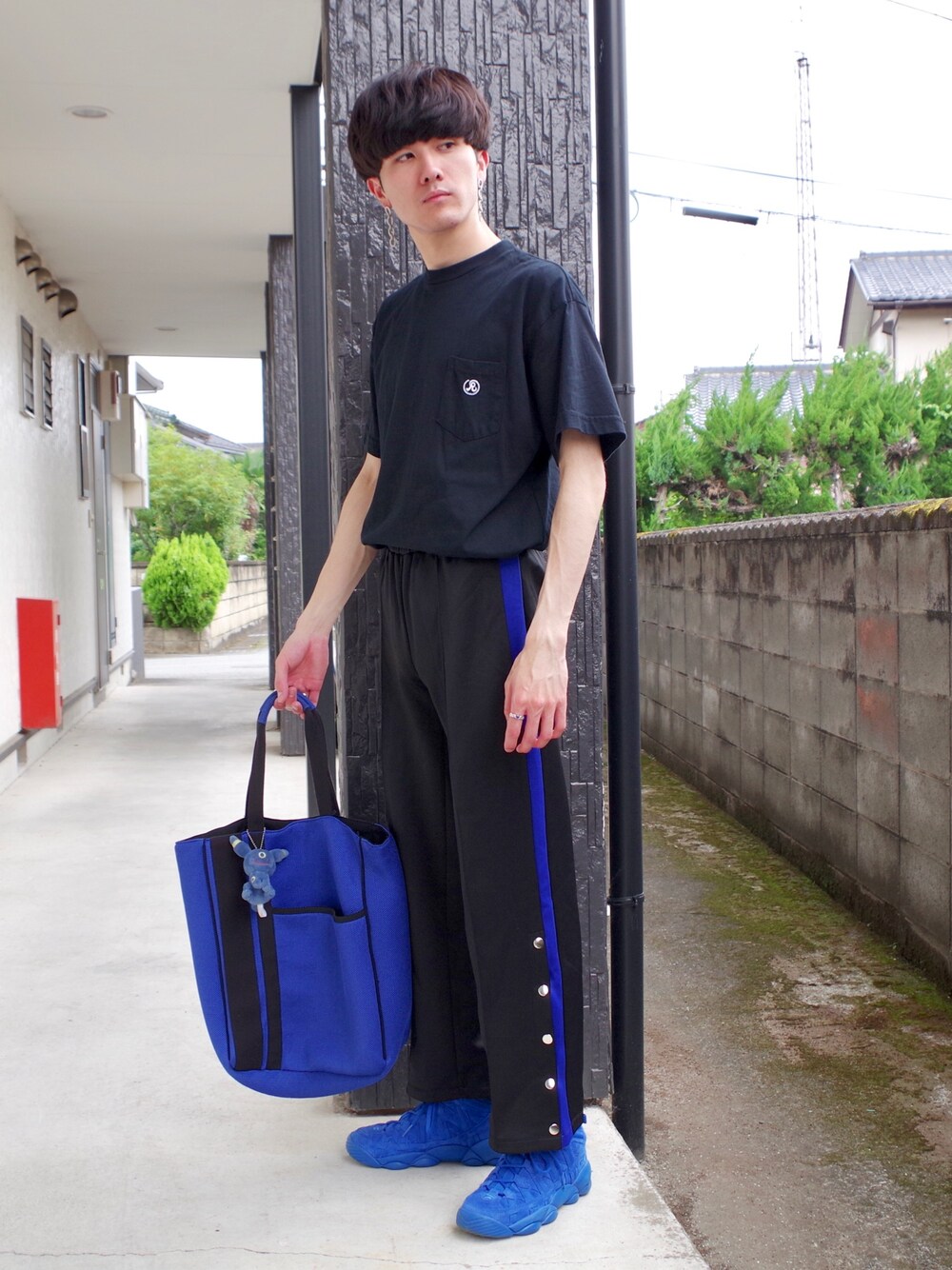 ブラック系のTシャツ/カットソー、ブラック系のパンツ、ブルー系のトートバッグを着用したメンズの夏コーディネートの1枚目の写真