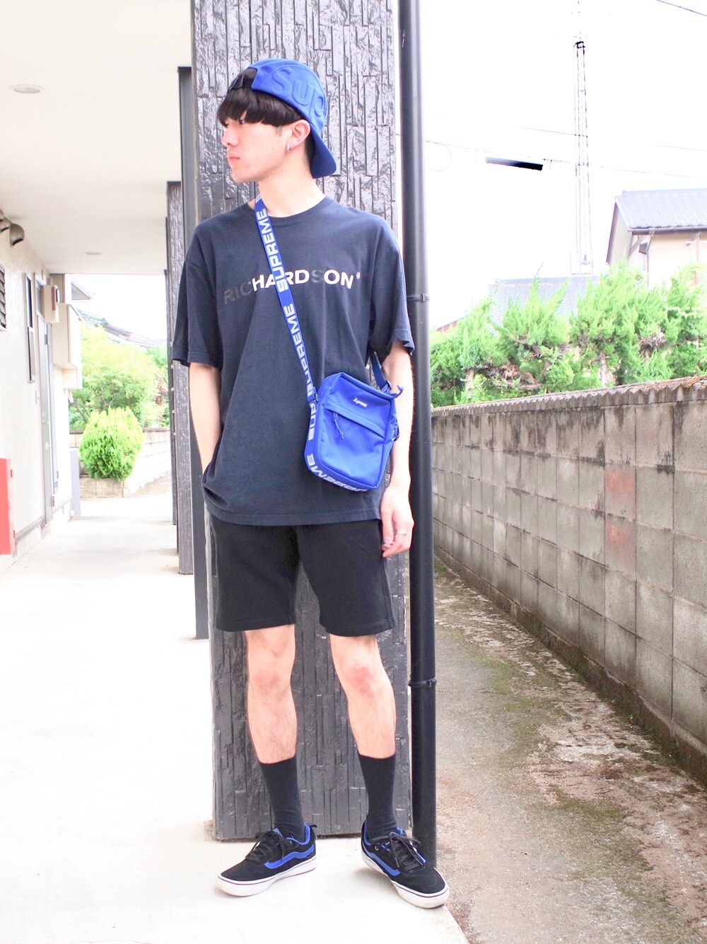 ブラック系のTシャツ/カットソー、ブルー系のショルダーバッグ、ブラック系のパンツを着用したメンズの夏コーディネートの1枚目の写真