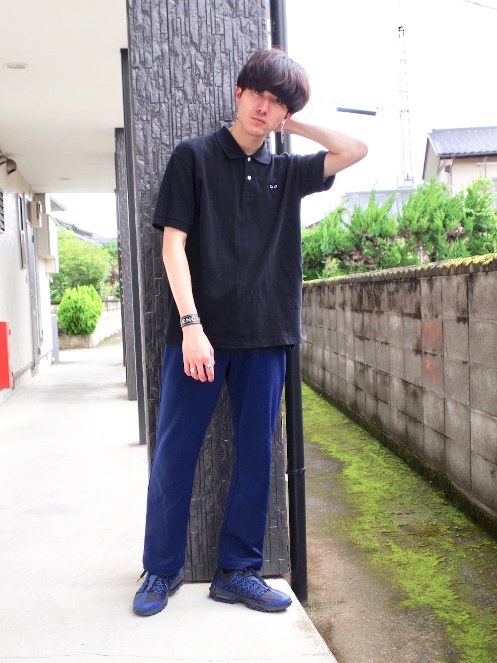 ブルー系のスニーカー、ブルー系のパンツ、ブラック系のポロシャツを着用したメンズの夏コーディネートの1枚目の写真