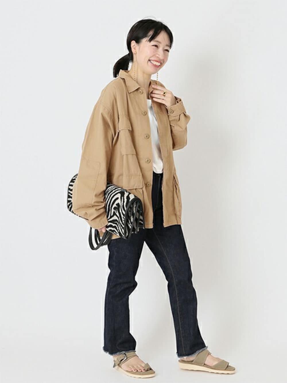 ベージュ系のミリタリージャケットを着用したレディースの冬コーディネートの1枚目の写真