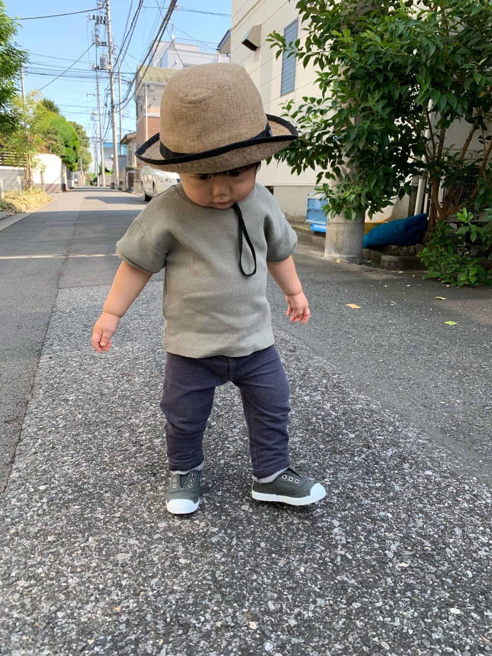 ブルー系のデニムパンツ、グレー系のスニーカー、ベージュ系のハットを着用したキッズの秋コーディネートの1枚目の写真