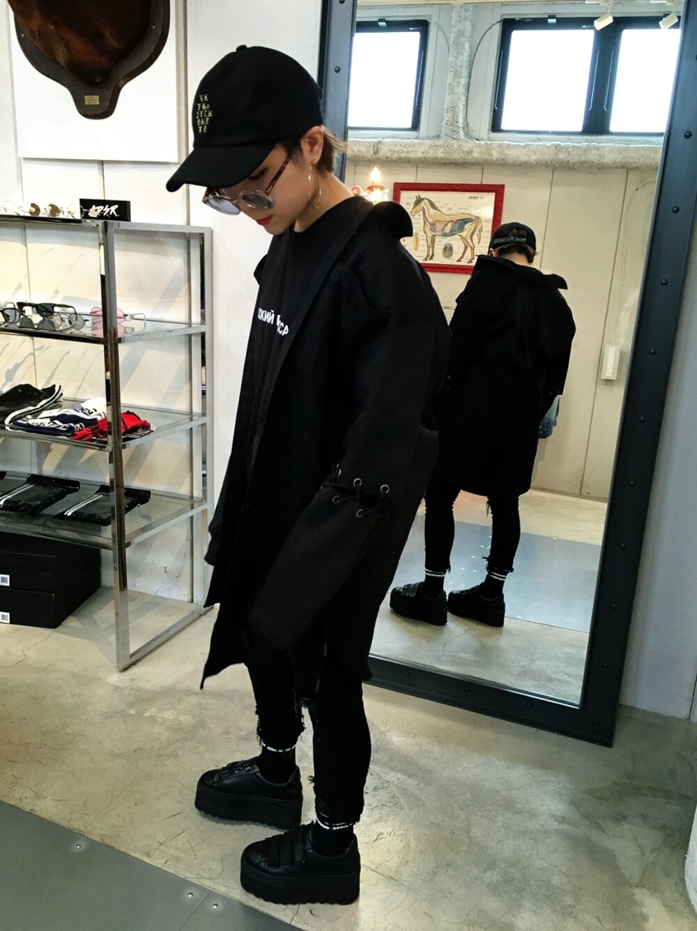 ブラック系のブーツ、ブラック系のシャツ/ブラウス、ブラック系のキャップを着用したレディースの冬コーディネートの1枚目の写真