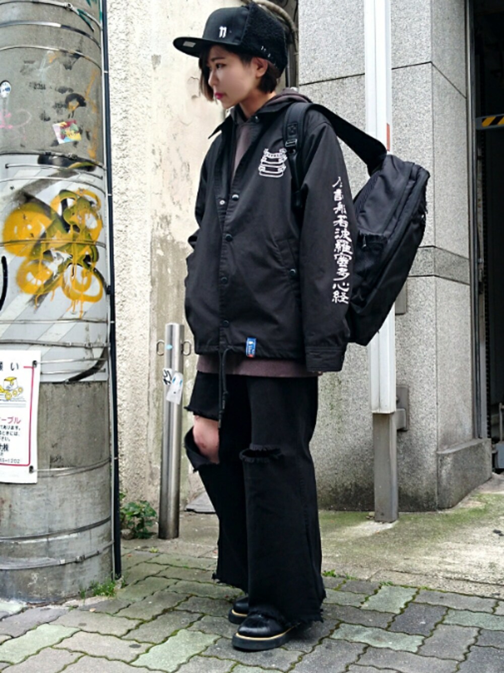 ブラック系のナイロンジャケット、ブラック系のデニムパンツ、ブラック系のブーツを着用したレディースの秋コーディネートの1枚目の写真