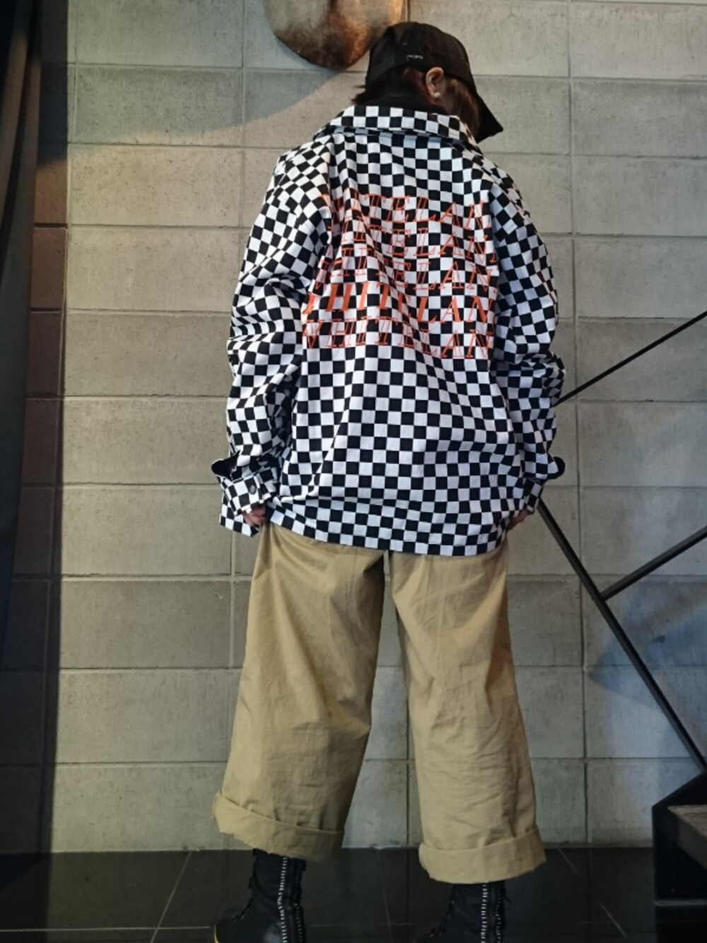 ホワイト系のブルゾン、ブラック系のキャップを着用したレディースの冬コーディネートの1枚目の写真