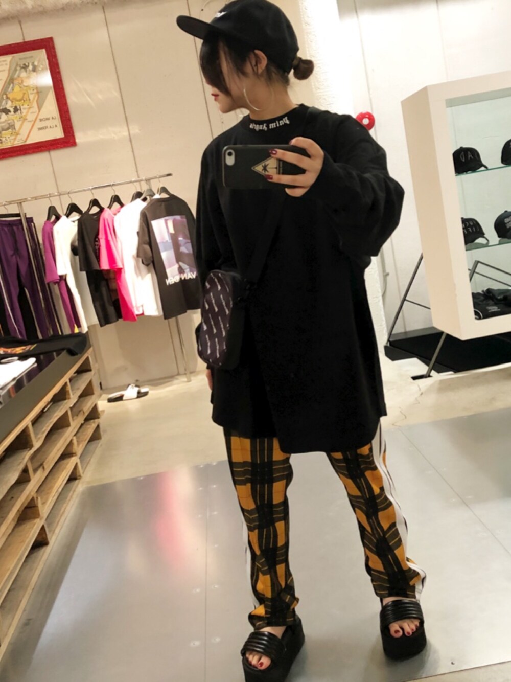 ブラック系のTシャツ/カットソー、イエロー系のスラックス、ブラック系のキャップを着用したレディースの夏コーディネートの1枚目の写真