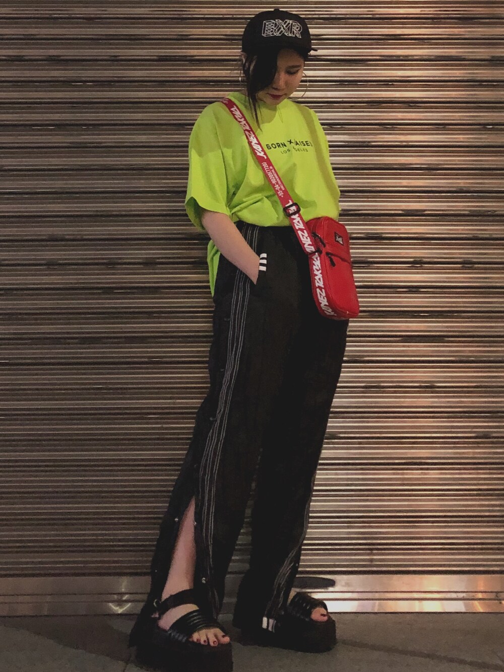 ブラック系のスラックス、レッド系のショルダーバッグ、レッド系のショルダーバッグを着用したレディースの夏コーディネートの1枚目の写真