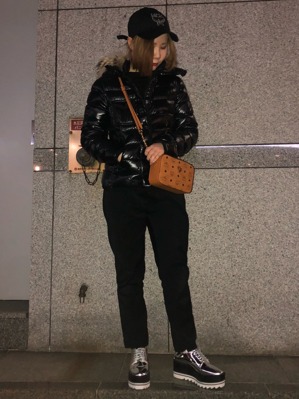 ブラウン系のショルダーバッグ、ブラック系のジャケット/アウター、シルバー系のシューズを着用したレディースの冬コーディネートの1枚目の写真