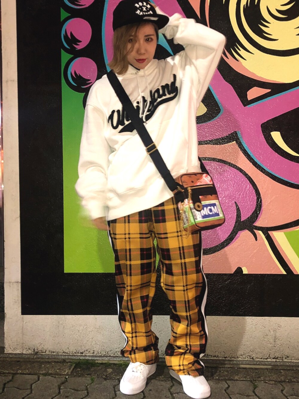 ホワイト系のパーカー、イエロー系のその他パンツ、ブラウン系のバッグを着用したレディースの冬コーディネートの1枚目の写真