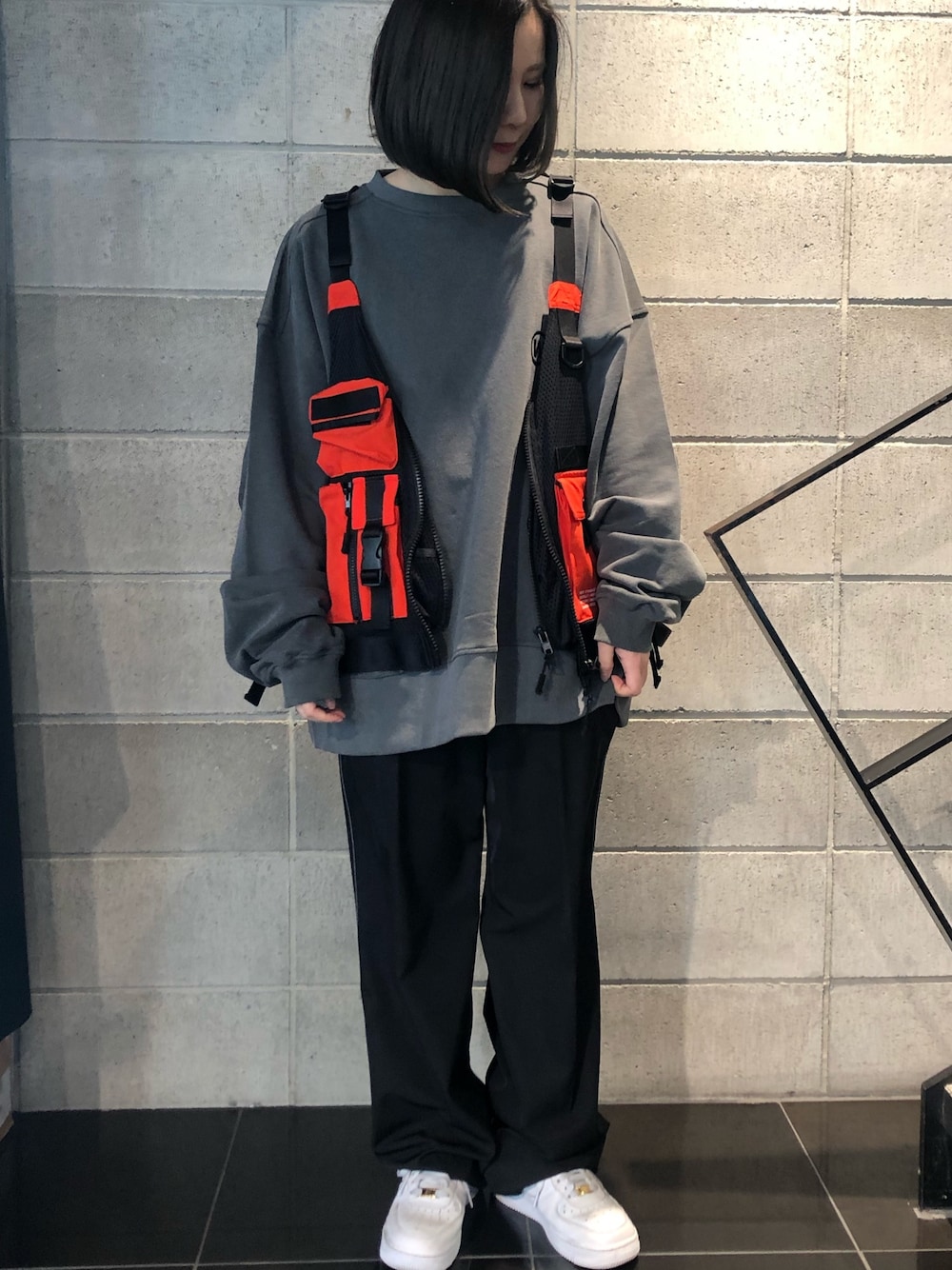 オレンジ系のベスト、ブラック系のその他パンツ、ブラック系のスウェットを着用したレディースの冬コーディネートの1枚目の写真