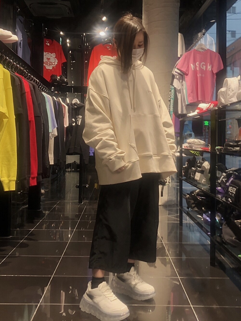 ベージュ系のパーカー、ブラック系のその他パンツ、ホワイト系のスニーカーを着用したレディースの冬コーディネートの1枚目の写真