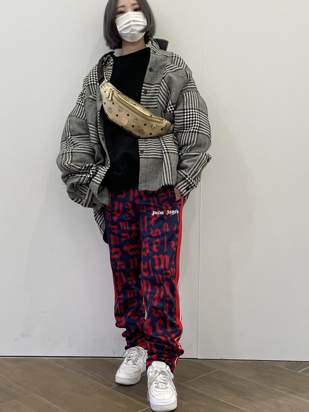 ブラック系のシャツ/ブラウス、ゴールド系のボディバッグ/ウエストポーチ、レッド系のパンツを着用したレディースの冬コーディネートの1枚目の写真