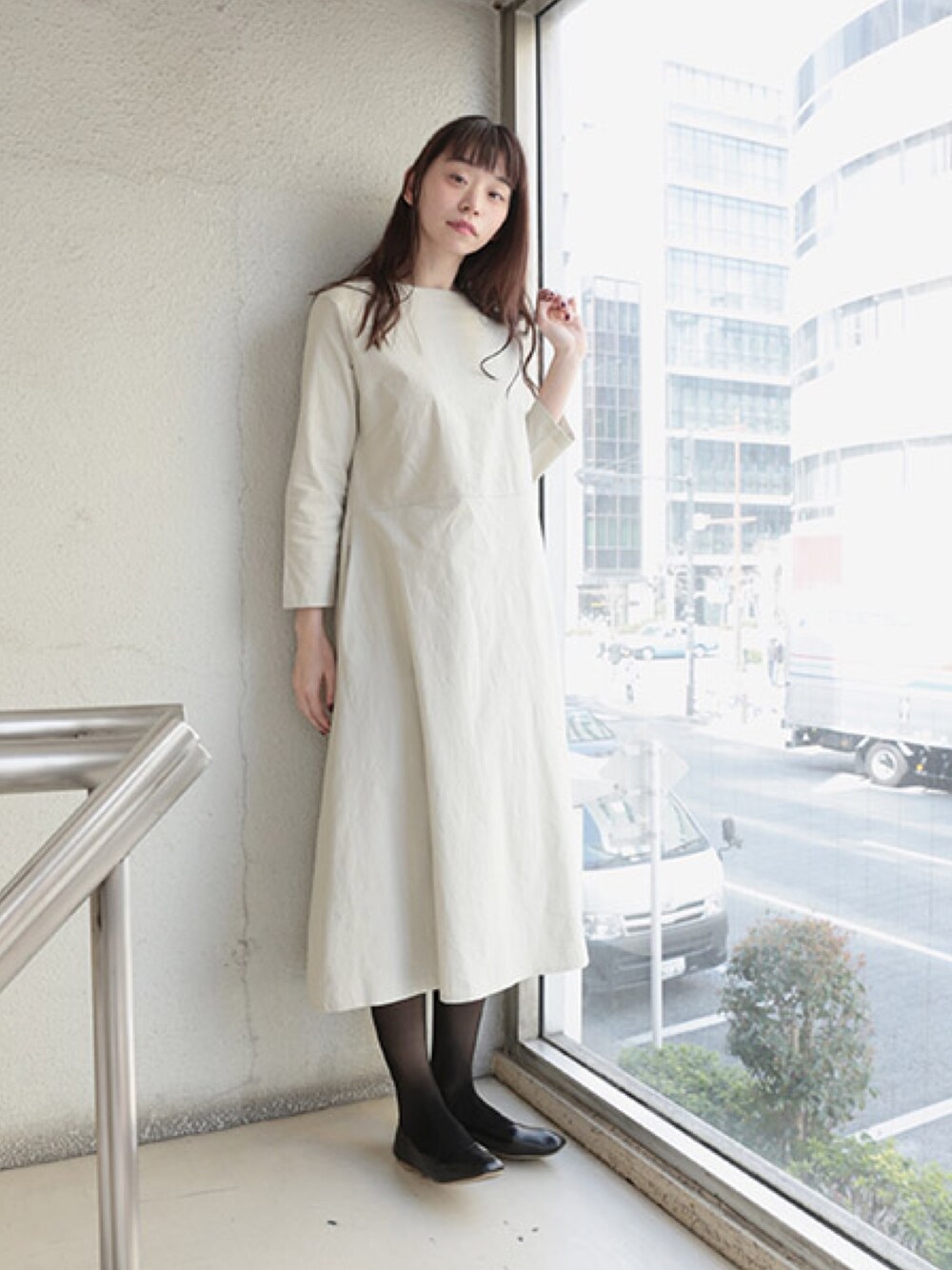 グレー系のワンピースを着用したレディースの春コーディネートの1枚目の写真
