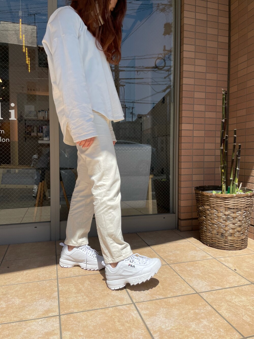 ホワイト系のスニーカー、ホワイト系のデニムパンツ、ホワイト系のパーカーを着用したレディースの春コーディネートの1枚目の写真