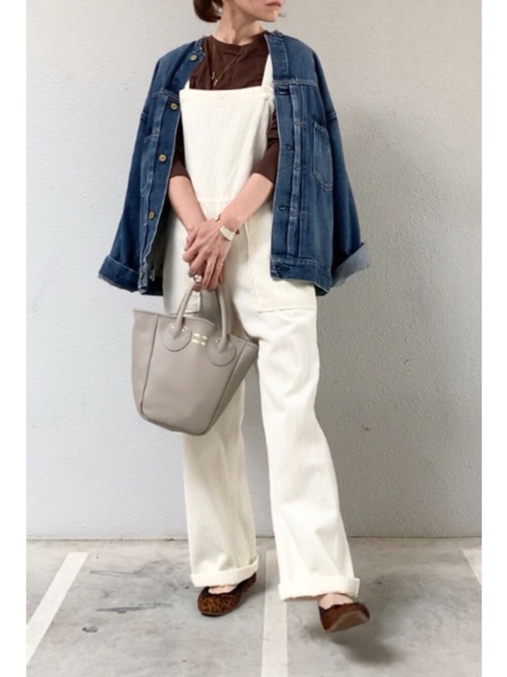 ブルー系のブルゾン、ホワイト系のサロペット/オーバーオール、ベージュ系のトートバッグを着用したレディースの秋コーディネートの1枚目の写真