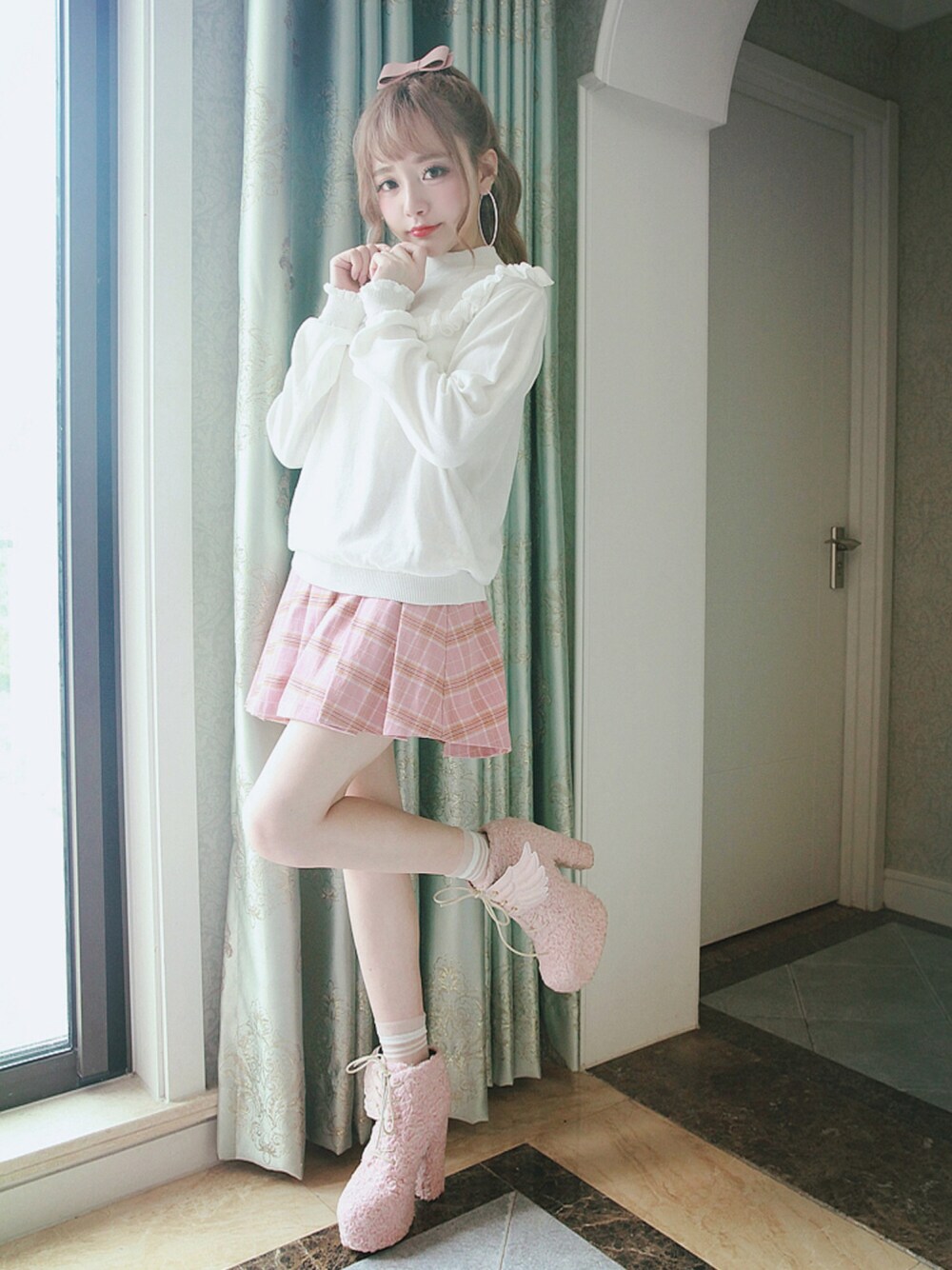 ホワイト系のニット/セーター、ピンク系のスカートを着用したレディースの冬コーディネートの1枚目の写真