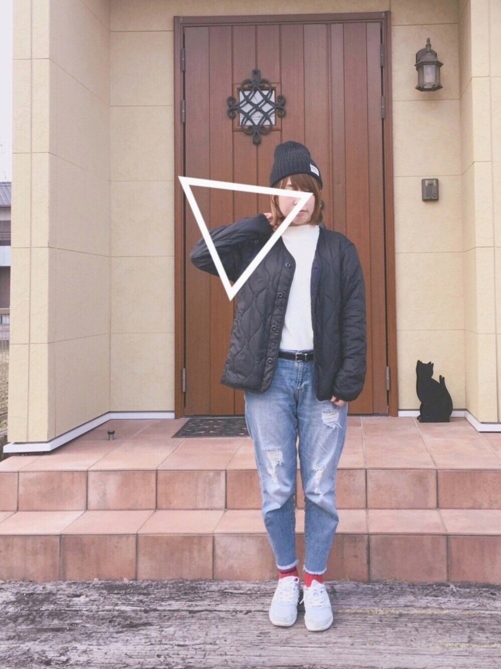 ブラック系のミリタリージャケット、ホワイト系のニット/セーター、ブルー系のデニムパンツを着用したレディースの春コーディネートの1枚目の写真