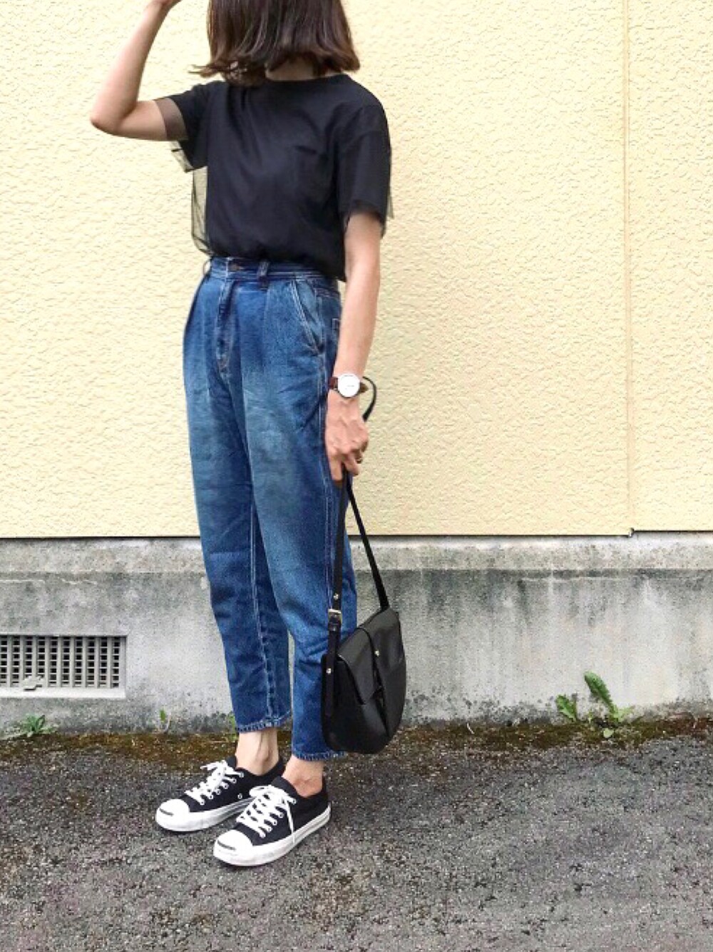 ブラック系のTシャツ/カットソー、ブルー系のデニムパンツ、ブラック系のハンドバッグを着用したレディースの春コーディネートの1枚目の写真