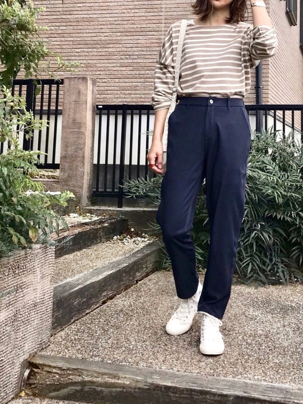 ブルー系のその他パンツ、ブラウン系のTシャツ/カットソー、ホワイト系のスニーカーを着用したレディースの春コーディネートの1枚目の写真