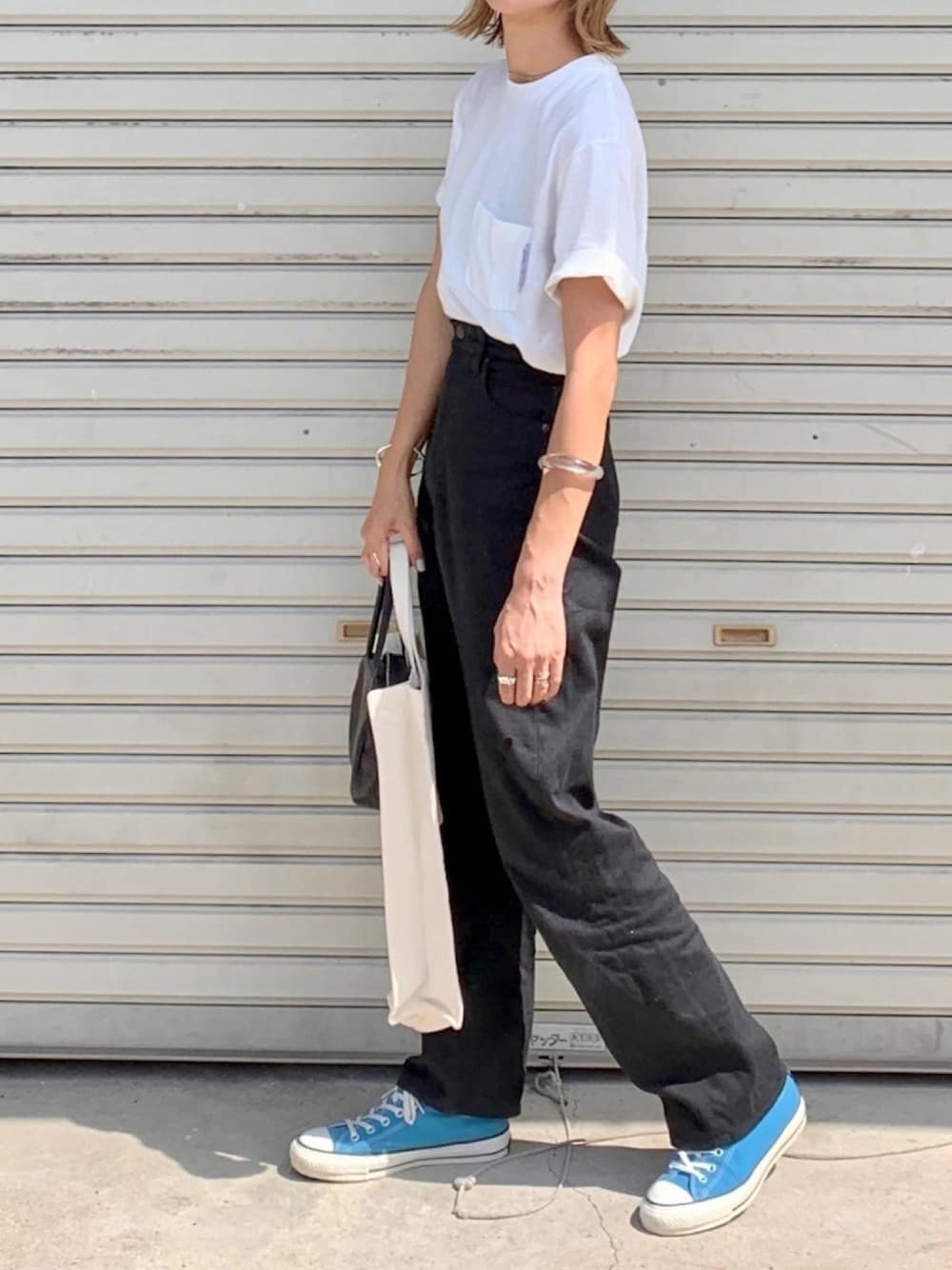 ホワイト系のTシャツ/カットソー、ブラック系のデニムパンツ、ブルー系のスニーカーを着用したレディースの夏コーディネートの1枚目の写真