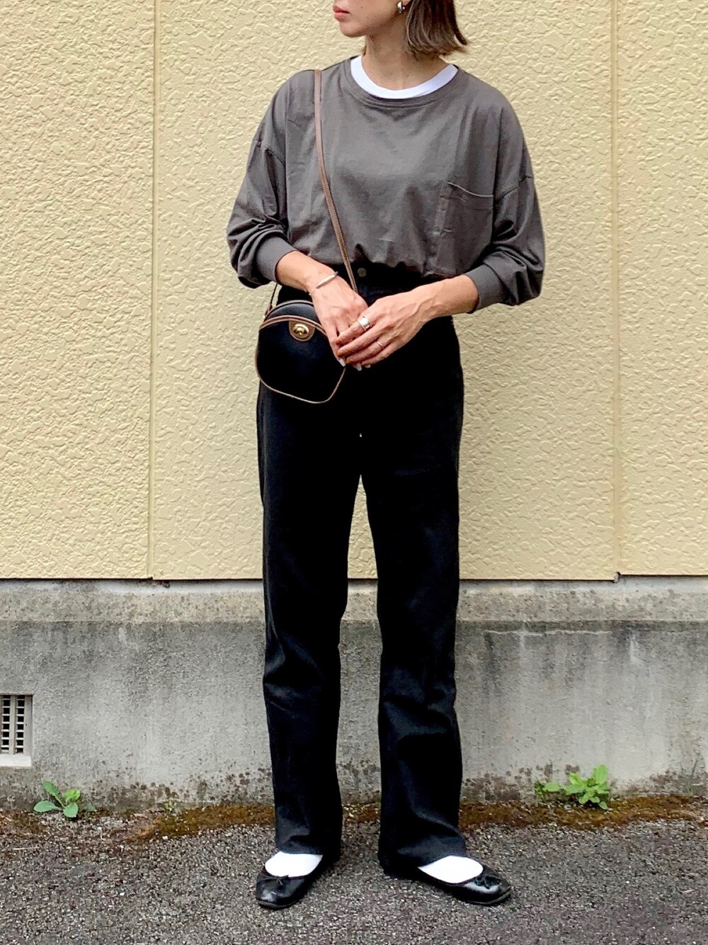 ブラック系のTシャツ/カットソー、ブラック系のショルダーバッグ、ブラック系のレインシューズを着用したレディースの秋コーディネートの1枚目の写真
