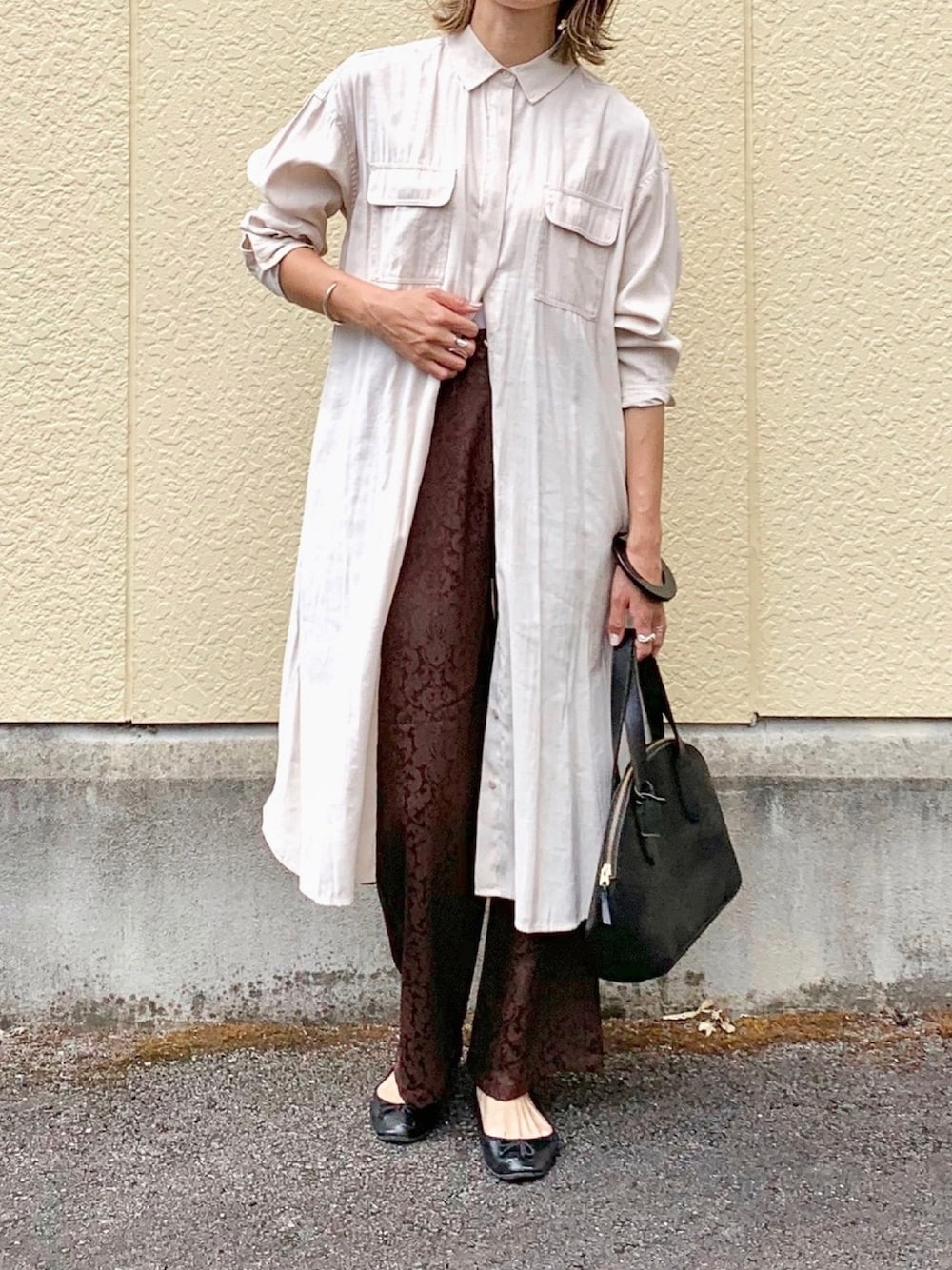 ブラウン系のその他パンツ、ベージュ系のワンピース、ブラック系のボストンバッグを着用したレディースの秋コーディネートの1枚目の写真