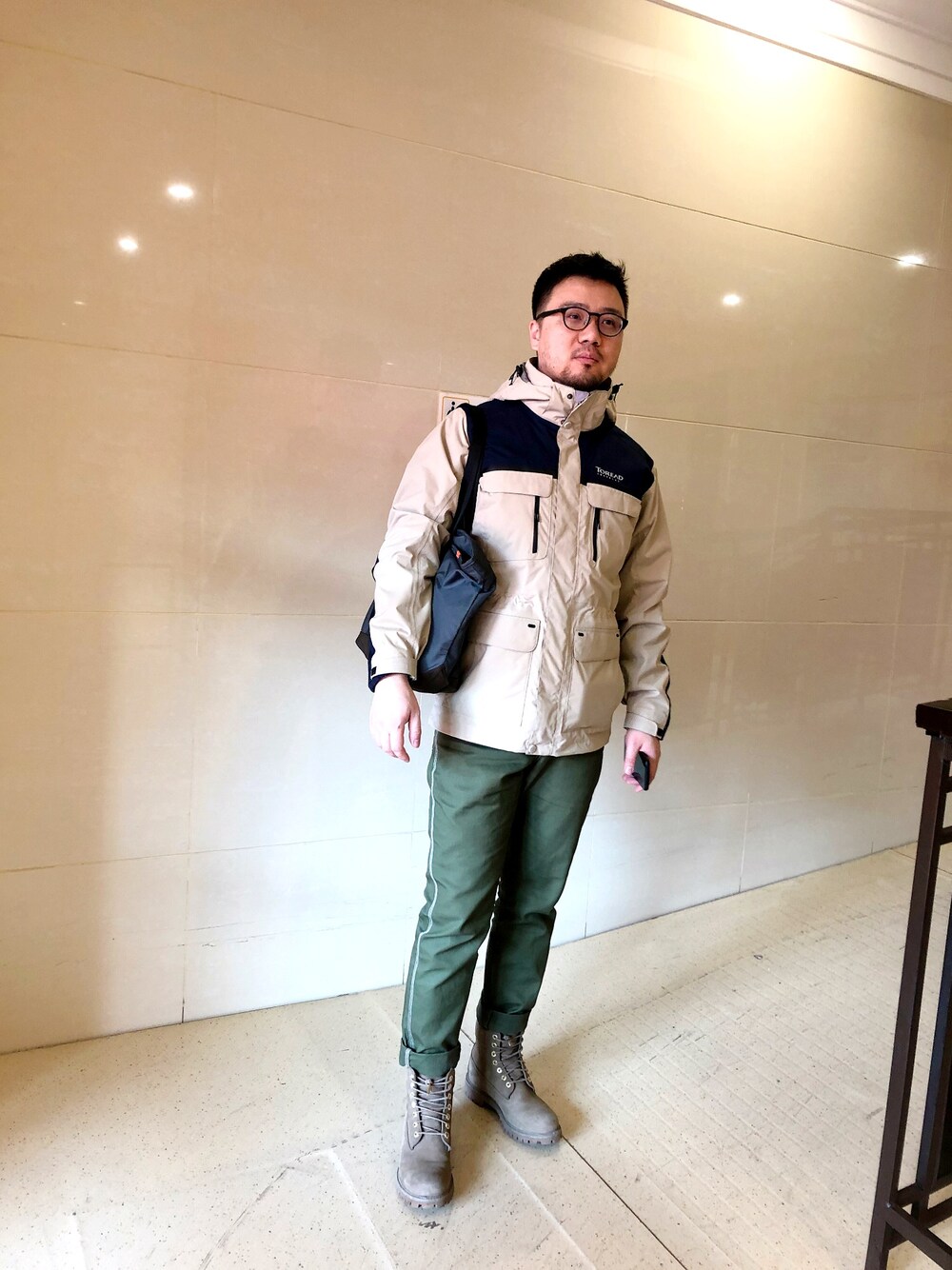 ベージュ系のマウンテンパーカー、グリーン系のデニムパンツ、グリーン系のモカシン/デッキシューズを着用したメンズの春コーディネートの1枚目の写真