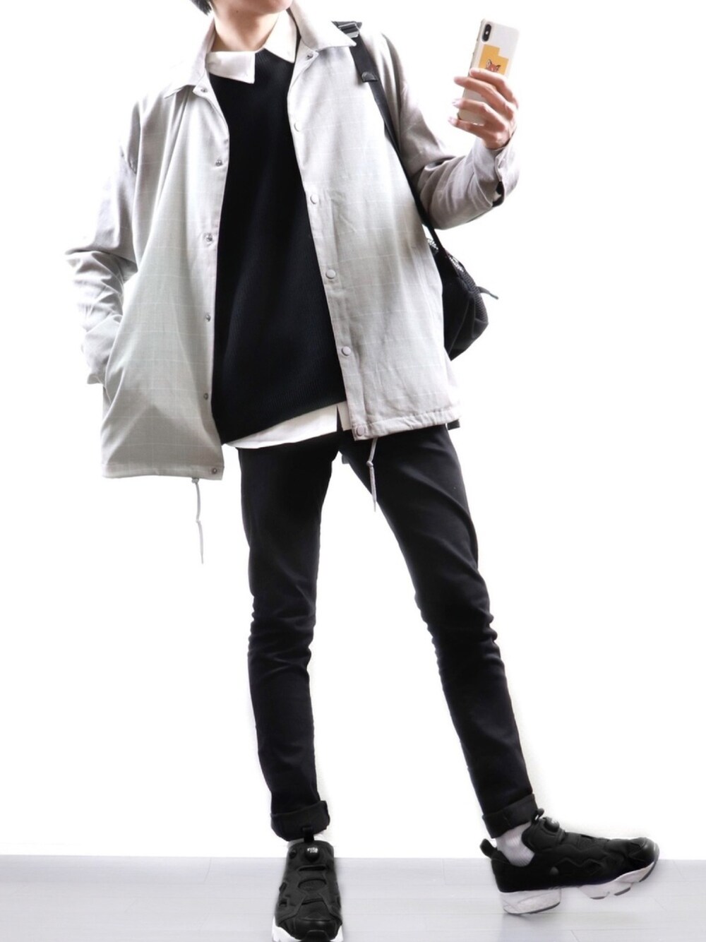 グレー系のその他アウター、ブラック系のニット/セーター、ホワイト系のシャツ/ブラウスを着用したメンズの春コーディネートの1枚目の写真