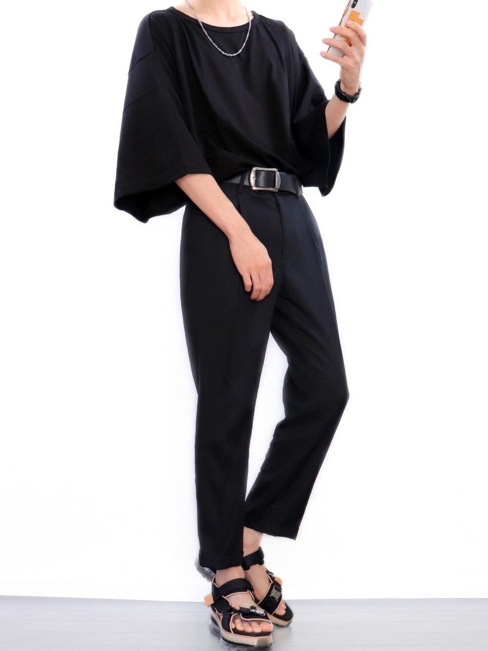 ブラック系のTシャツ/カットソー、ブラック系のスラックス、ブラック系のサンダルを着用したメンズの夏コーディネートの1枚目の写真