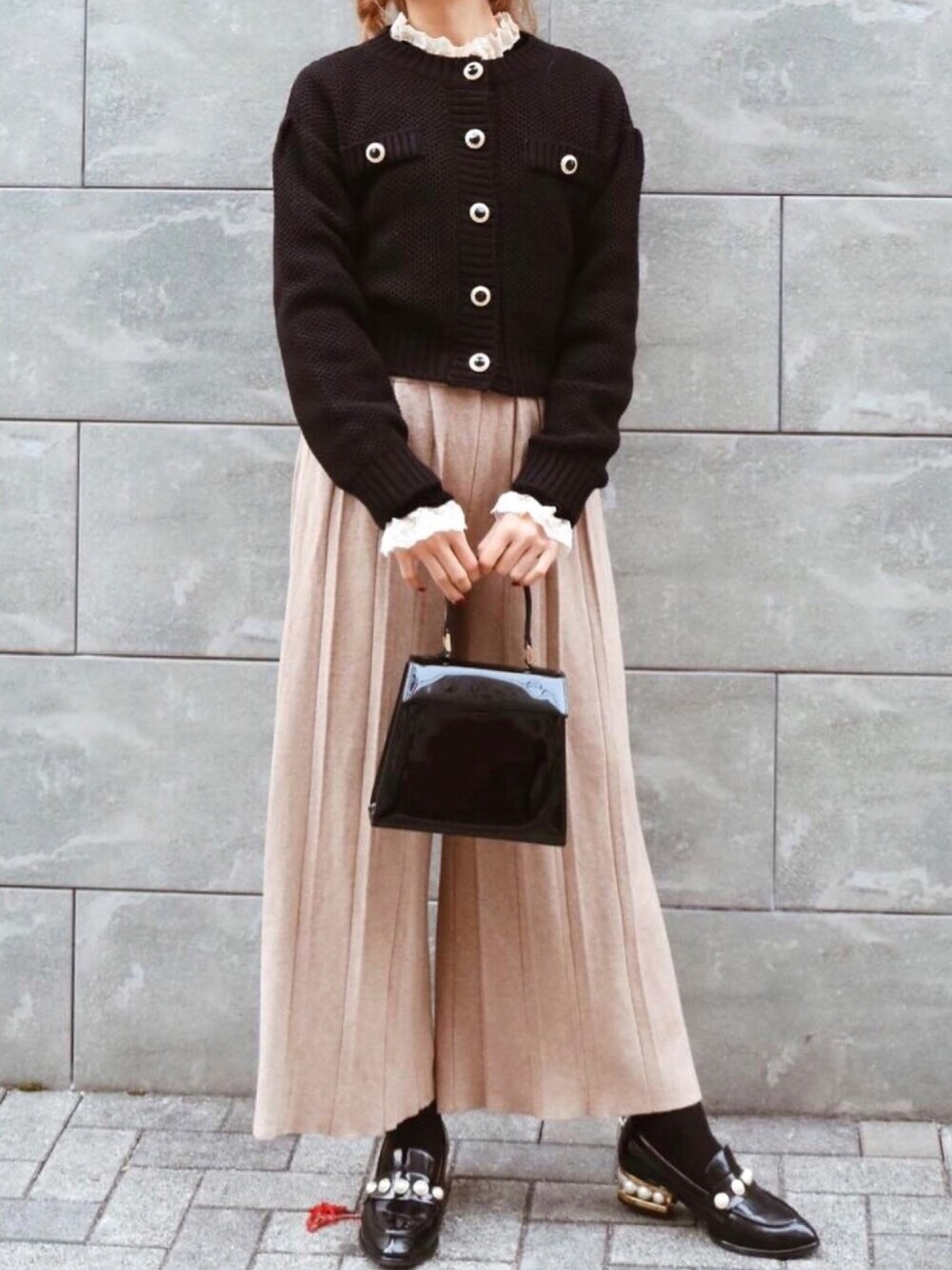 ベージュ系のパンツ、ブラック系のショルダーバッグ、ブラック系のシャツ/ブラウスを着用したレディースの冬コーディネートの1枚目の写真