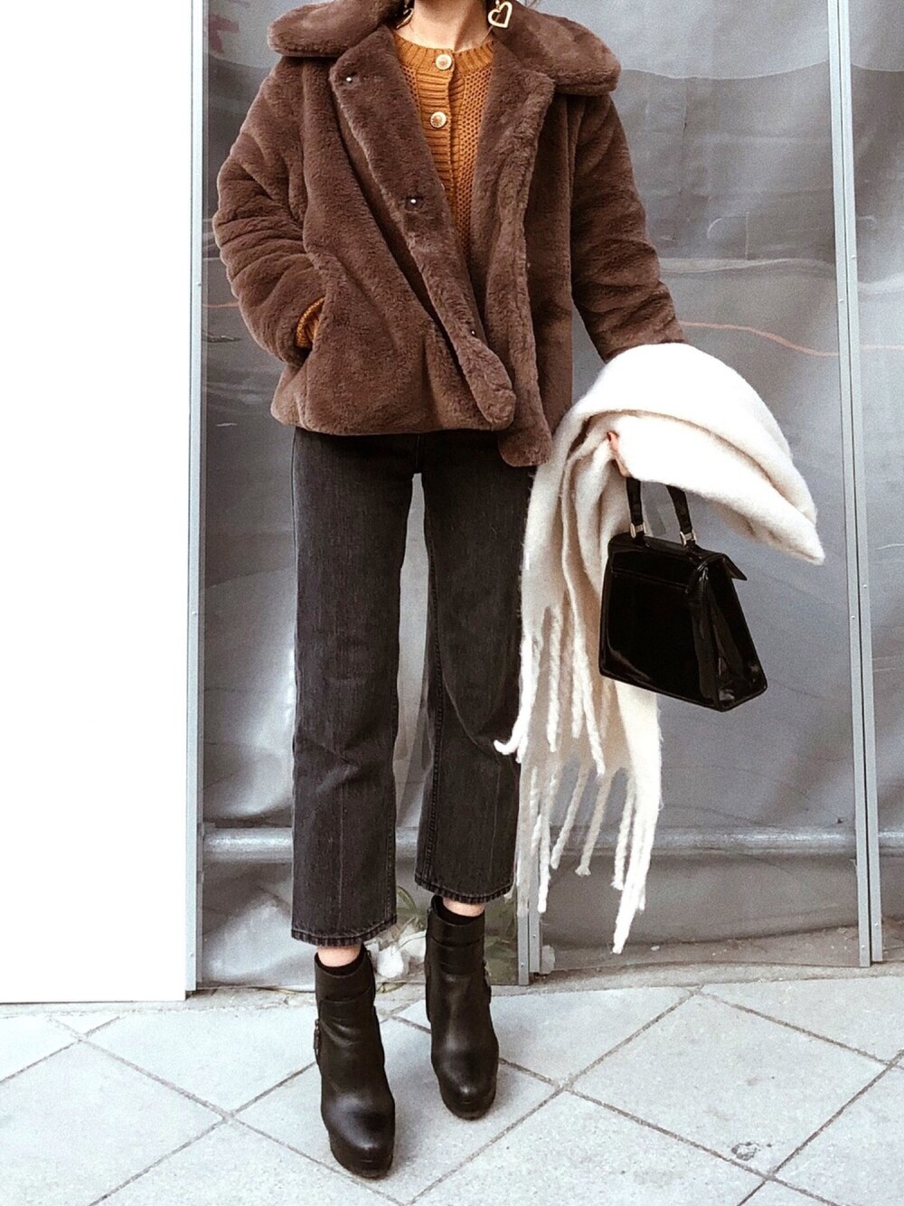 ブラウン系のジャケット/アウター、イエロー系のトップス、ブラック系のバッグを着用したレディースの冬コーディネートの1枚目の写真