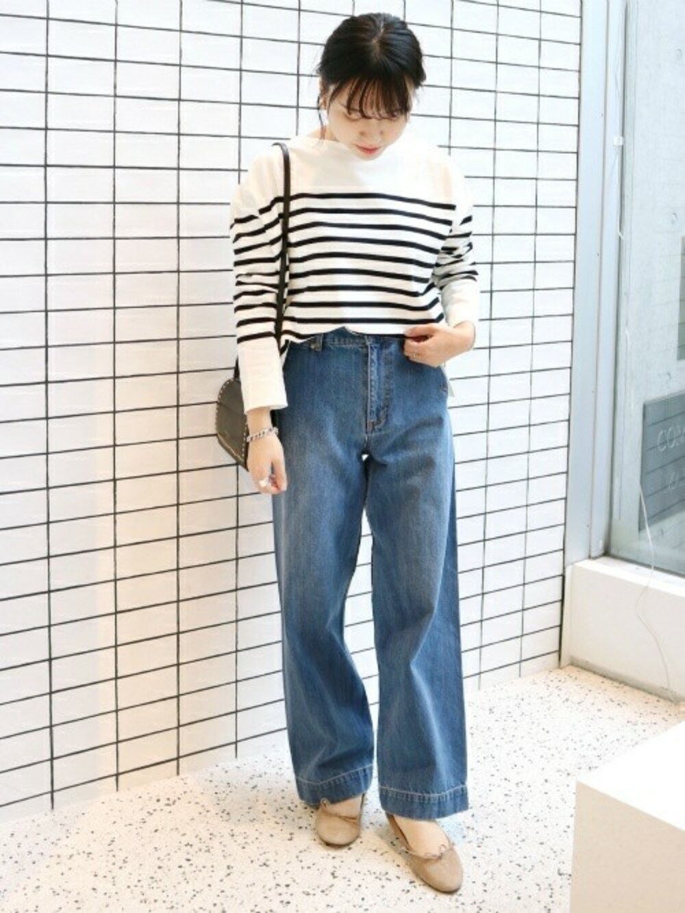 ブラック系のニット/セーター、ブルー系のデニムパンツ、ブラック系のショルダーバッグを着用したレディースの冬コーディネートの1枚目の写真