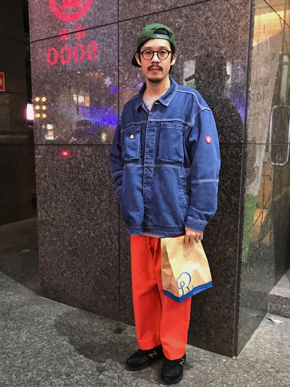 ブルー系のデニムジャケット、オレンジ系のチノパンツ、ブラック系のスニーカーを着用したメンズの冬コーディネートの1枚目の写真