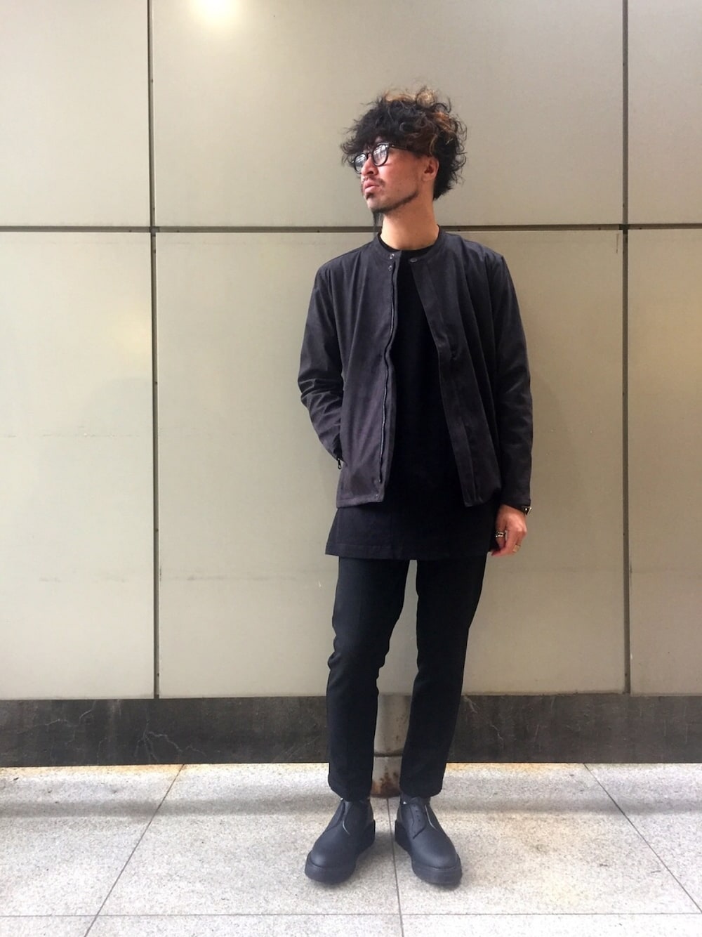 ブラック系のマウンテンパーカー、ブラック系のTシャツ/カットソー、ブラック系のスラックスを着用したメンズの秋コーディネートの1枚目の写真