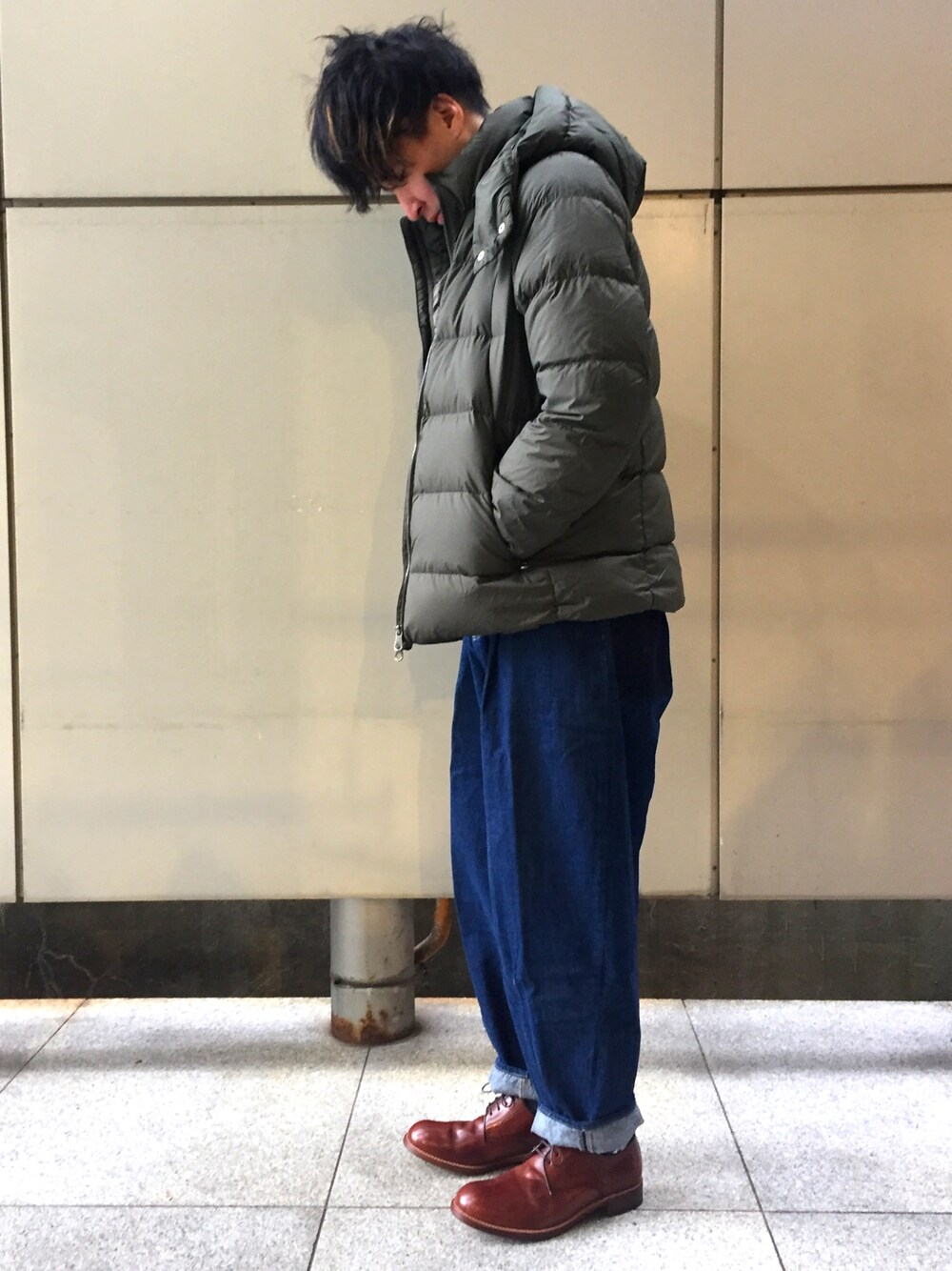 グリーン系のダウンジャケット/コート、ブルー系のデニムパンツ、ブラウン系のドレスシューズを着用したメンズの冬コーディネートの1枚目の写真