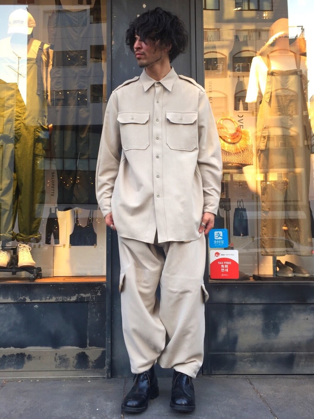 ベージュ系のシャツ/ブラウス、ベージュ系のパンツ、ブラック系のブーツを着用したメンズの春コーディネートの1枚目の写真