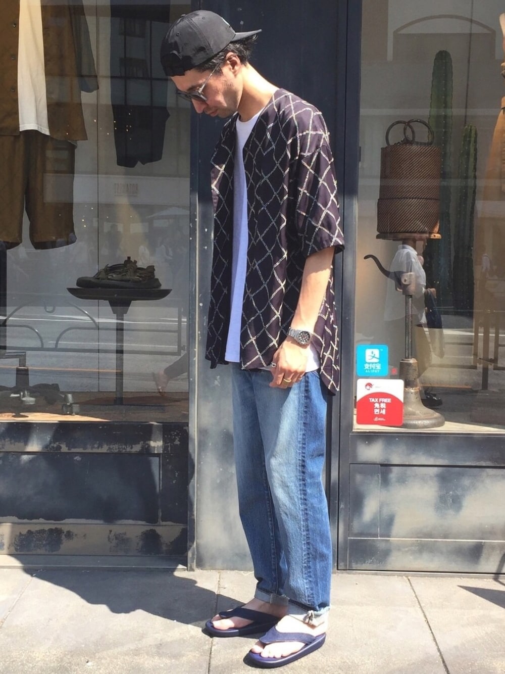 ブルー系のデニムパンツ、ブラック系のシャツ/ブラウス、ブルー系のサンダルを着用したメンズの夏コーディネートの1枚目の写真