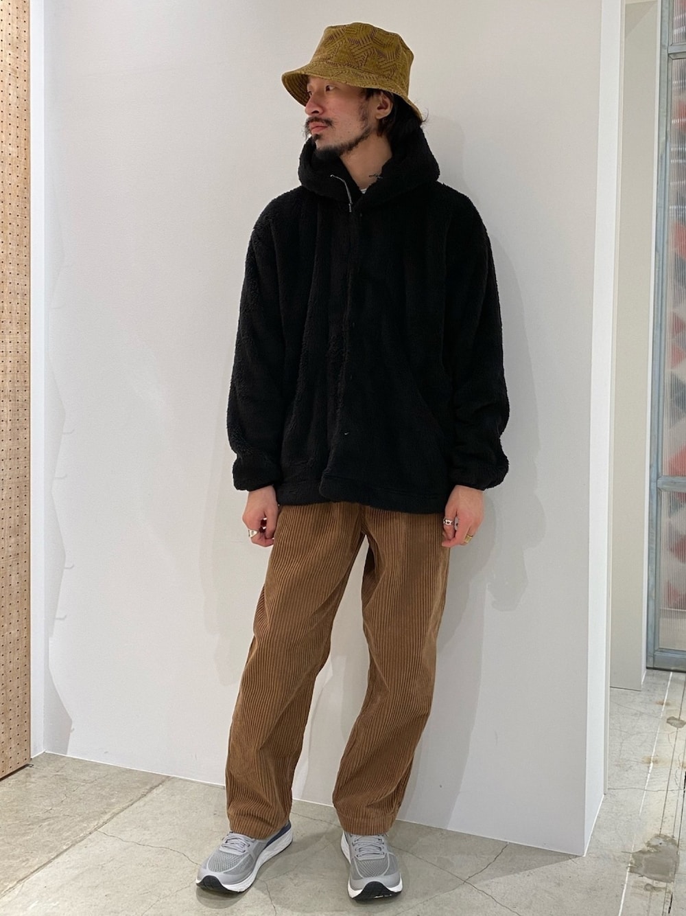 ブラック系のその他アウター、ブラウン系のその他パンツ、グレー系のスニーカーを着用したメンズの秋コーディネートの1枚目の写真