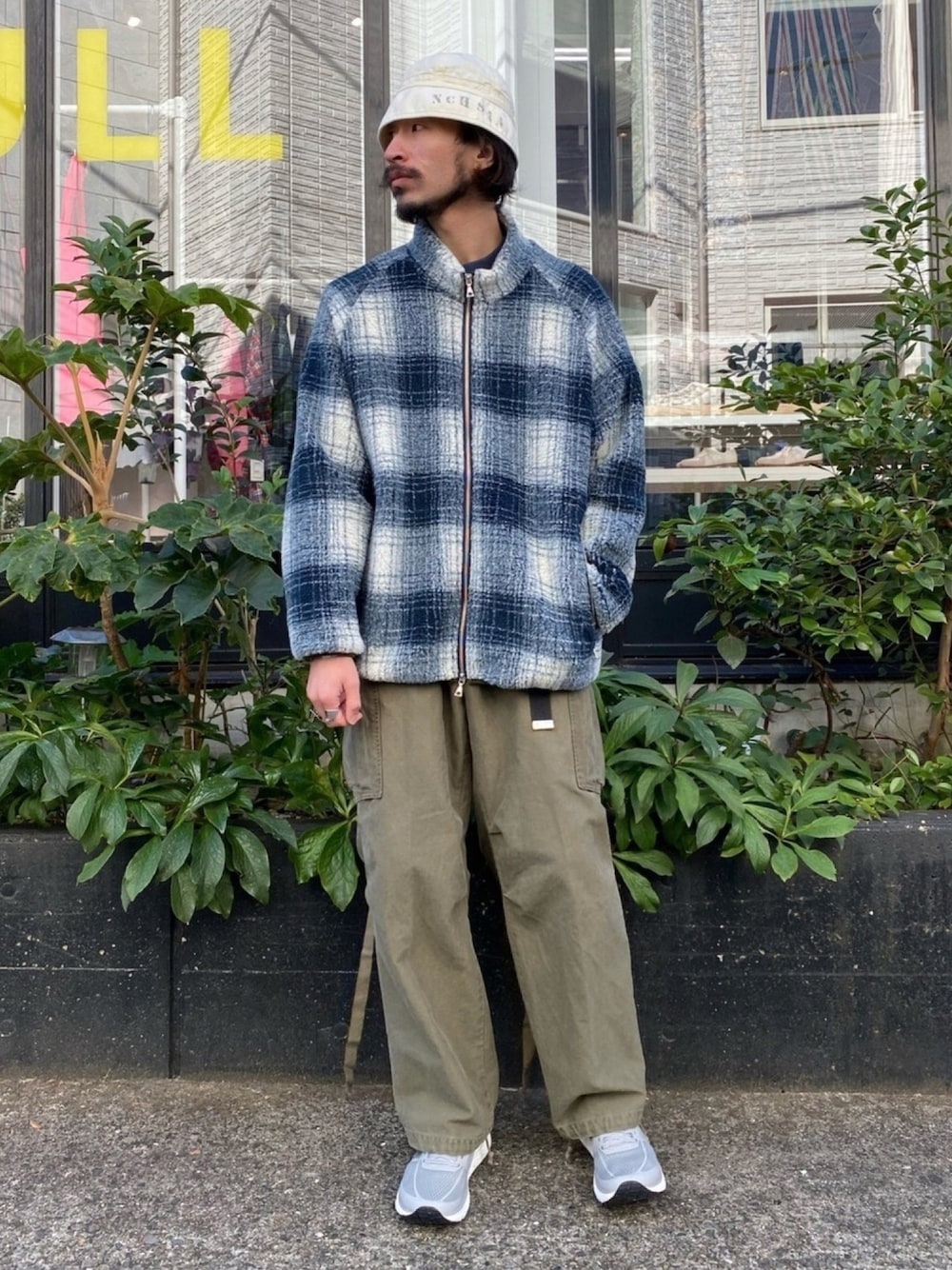 ブルー系のブルゾン、グリーン系のカーゴパンツ、グレー系のスニーカーを着用したメンズの秋コーディネートの1枚目の写真